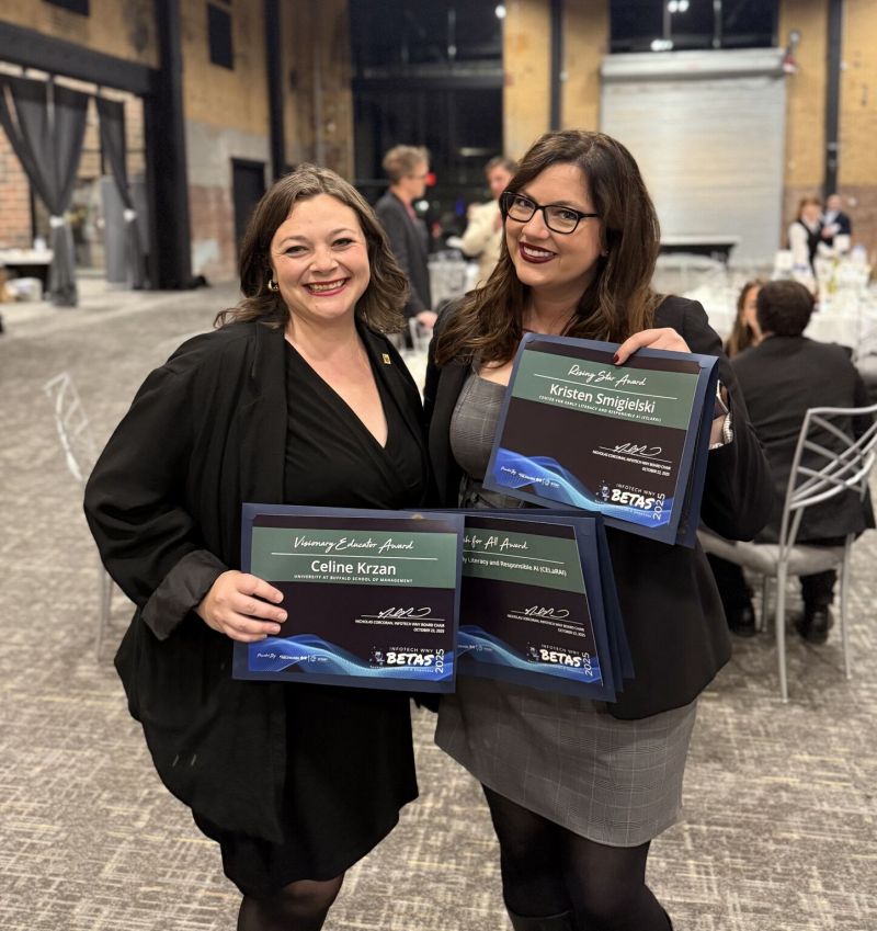 Two women pose together holding awards at an event, featuring 'Visionary Educator Award' and 'Rising Star Award' certificates.